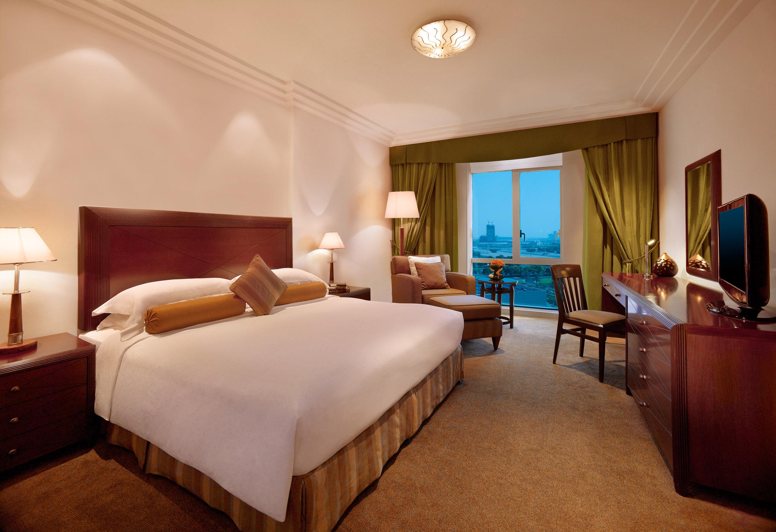 Grand Hyatt Dubai Hotel Ngoại thất bức ảnh The photo shows a well-furnished hotel room. It features a large bed with a light-colored comforter and decorative pillows. The walls are painted in a soft color, and there are lamps on either side of the bed. A cozy seating area is present, which in