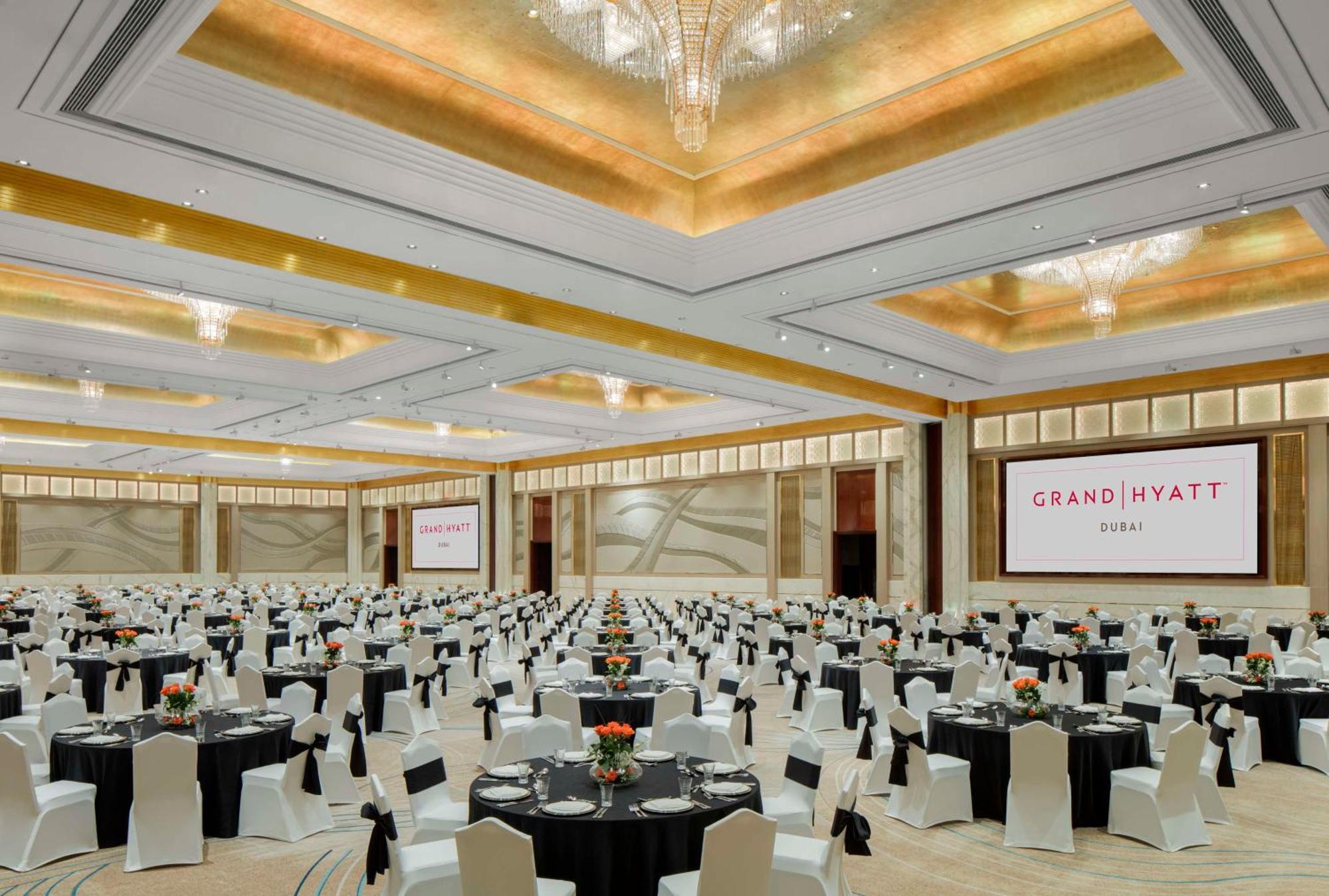Grand Hyatt Dubai Hotel Ngoại thất bức ảnh The image shows a large banquet hall set up for an event at the Grand Hyatt. The room is spacious with elegantly designed decor, featuring high ceilings and chandeliers. Numerous round tables are arranged throughout the space, each covered with black