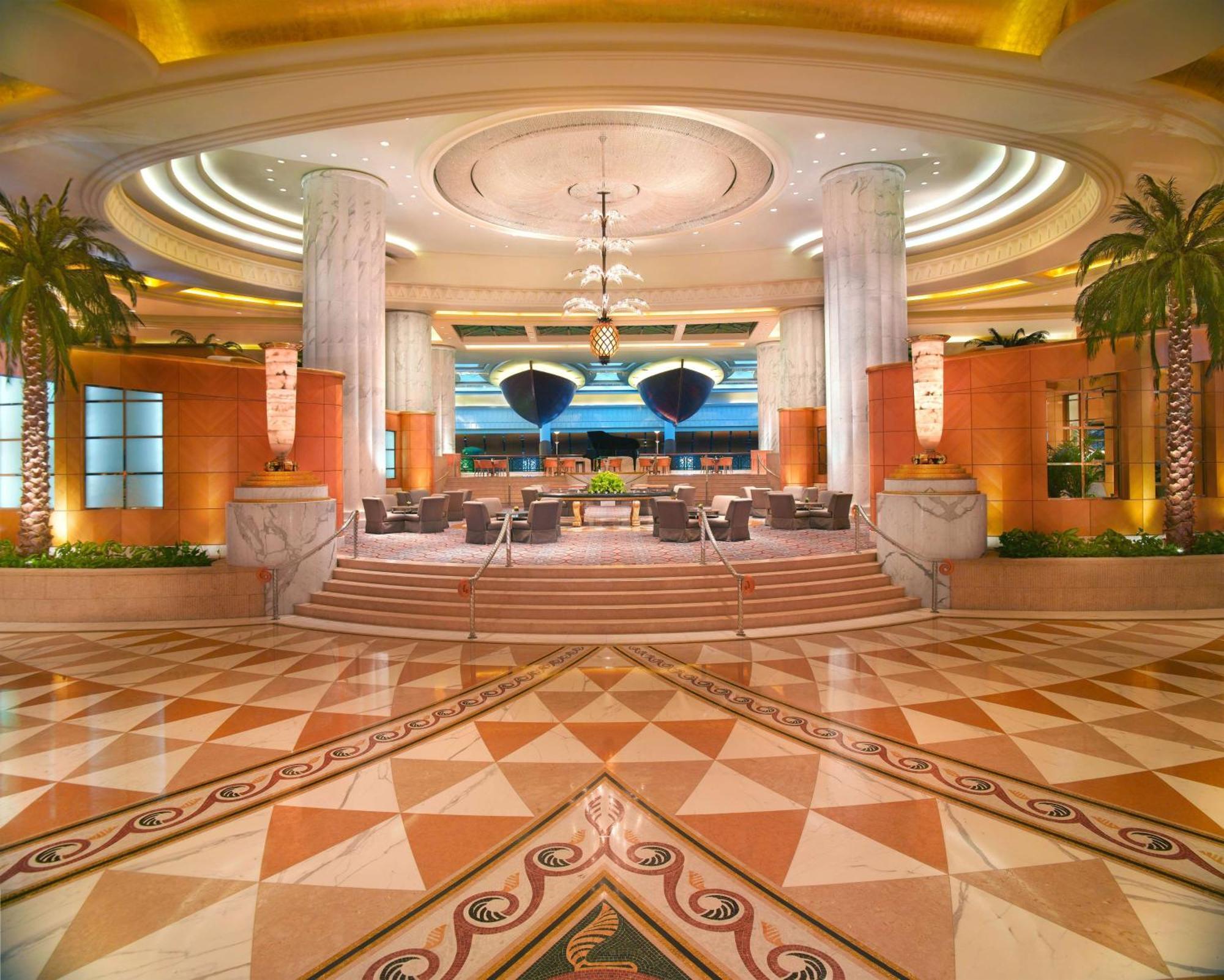Grand Hyatt Dubai Hotel Ngoại thất bức ảnh The photo depicts a luxurious hotel lobby. The space features high ceilings with elegant lighting and intricate architectural details. Tall columns stand prominently, and there are stylish seating arrangements visible. The floor is adorned with a geo